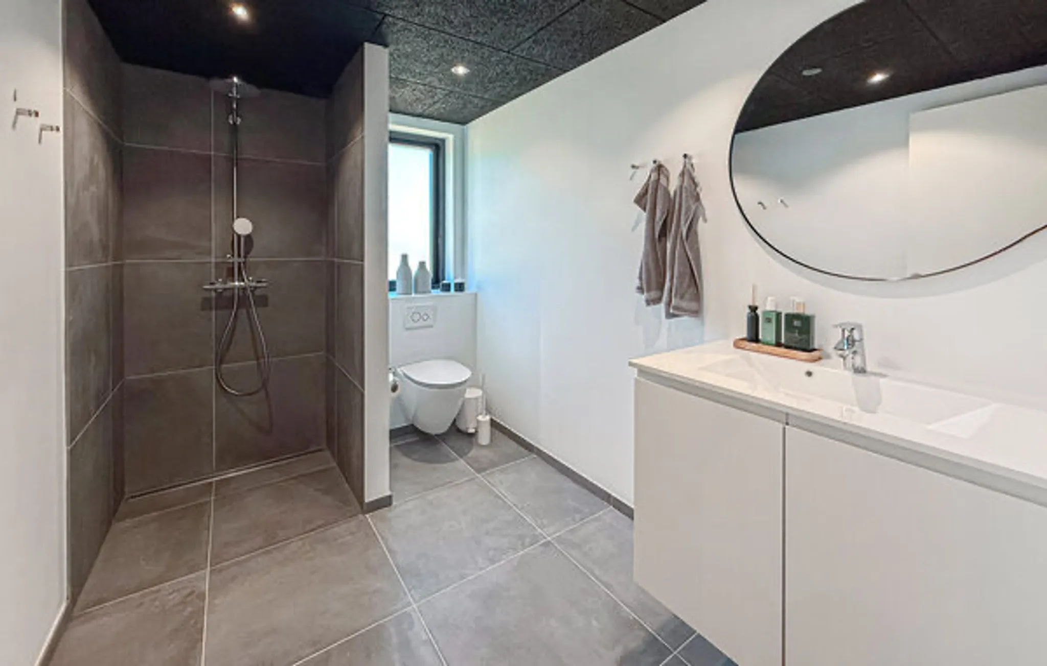 Nyt badeværelse med walk-in bruser, væghængt toilet og vask